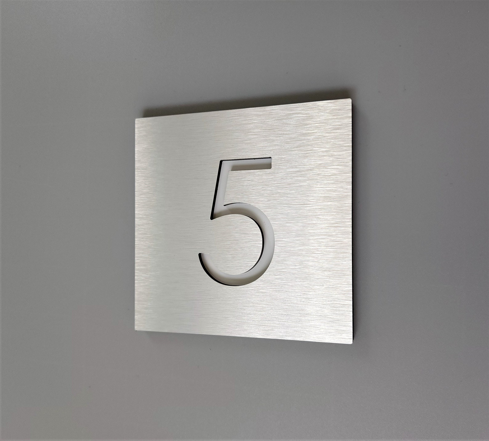 Building number 5 in brushed aluminum prepared with a clear coat of finish.
