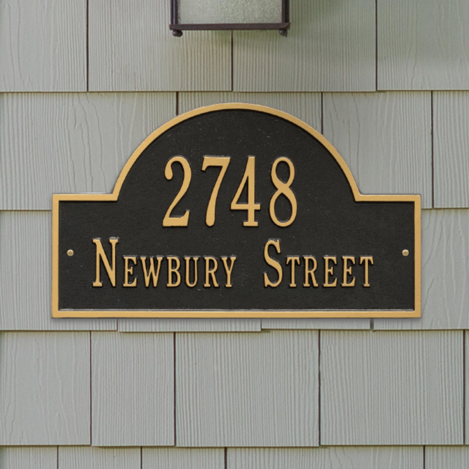 Bronze house number with period-appropriate serif typography and ornamental border, installed on a historic Victorian manor.